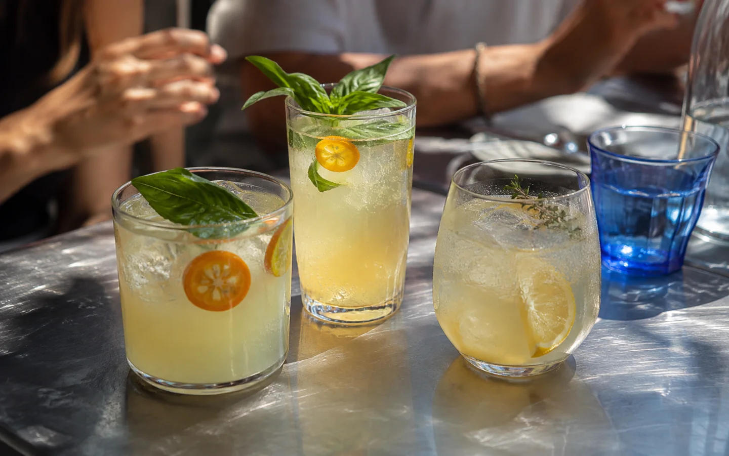 Three citrus and herb sodas on a bright cafe counter